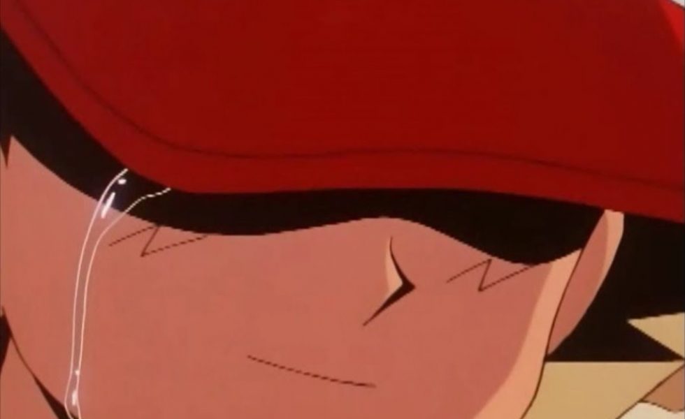 Personagem Ash de Pokémon derramando uma lágrima por seu olho direito, oculto pela aba do boné e a sombra feita por ela.