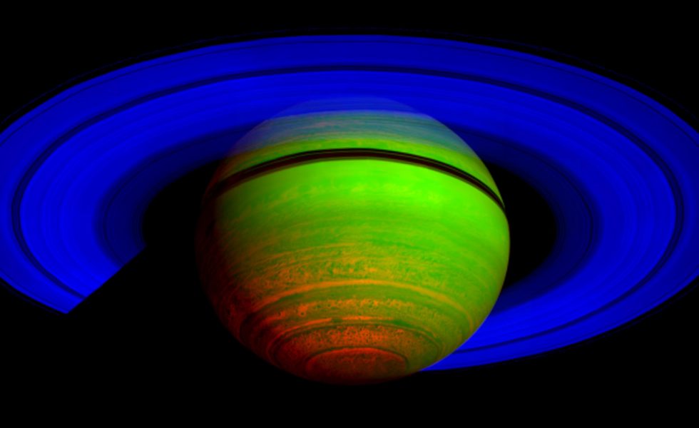 Imagem de Saturno obtida por radiação infravermelha colorida artificialmente, o planeta apresenta coloração verde com a região polar avermelhada. Os anéis apresentam cor azul.