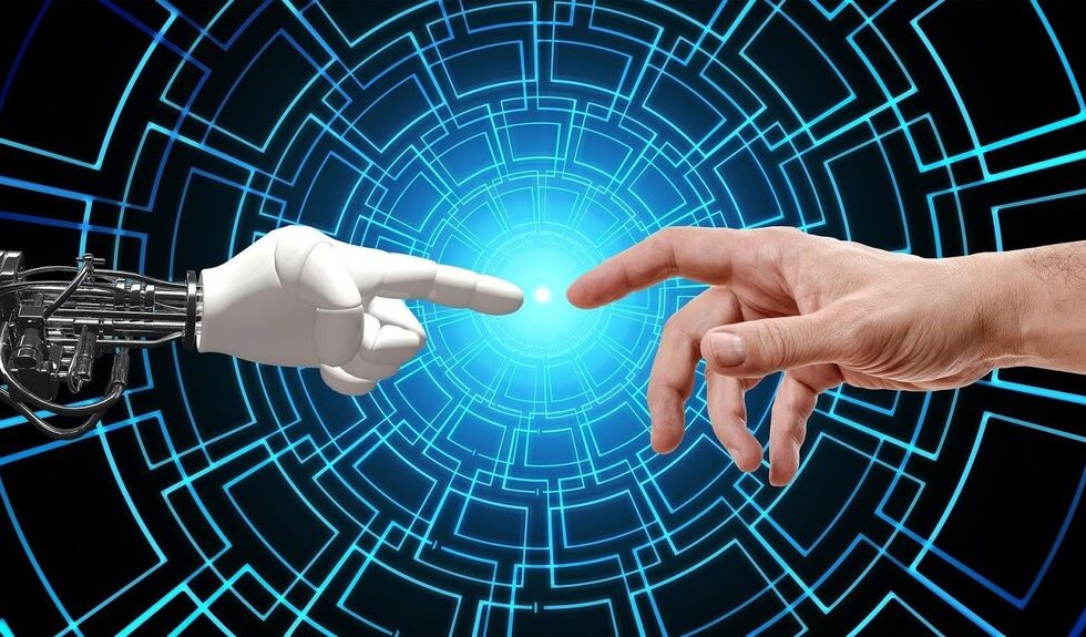 Imagem de uma mão robótica e uma mão humana indo de encontro uma à outra, com os dedos indicadores quase se tocando.