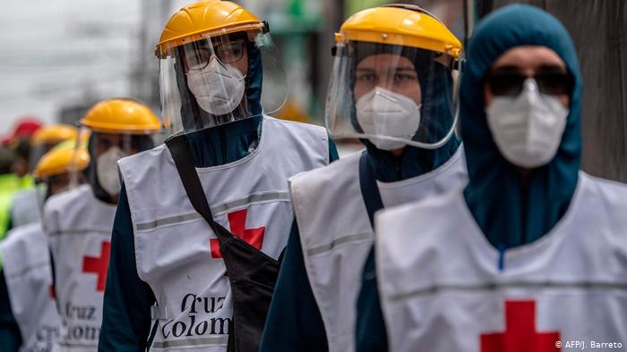 Fotografia de pessoas utilizando máscara, gorro e protetor facial, equipamentos de proteção individual contra o novo coronavírus.