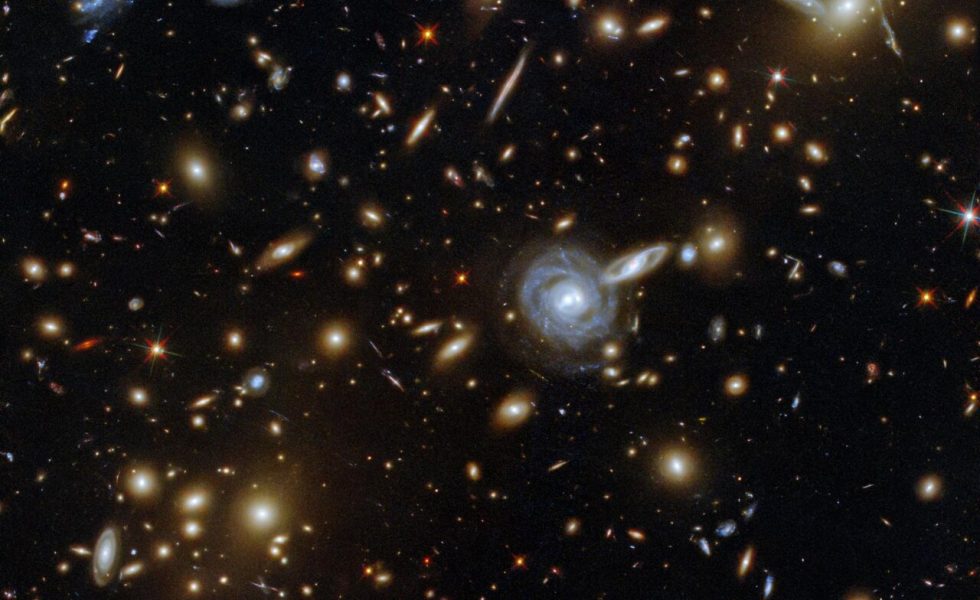 Aglomerado de Galáxias ACO S 295 com outras galáxias e estrelas ao fundo.