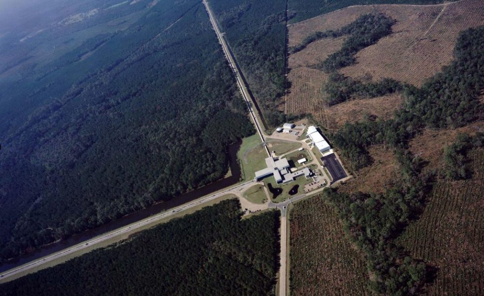 Imagem aérea mostra o LIGO (Observatório de Ondas Gravitacionais por Interferometria de Laser), com vegetação ao redor e seus tubos de 4 quilômetros.